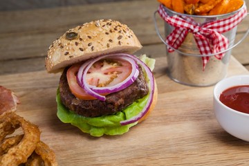 Hamburger, french fries, onion ring and tomato sauce on chopping