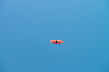 Paraglider in blue sky. Minimalistic style.