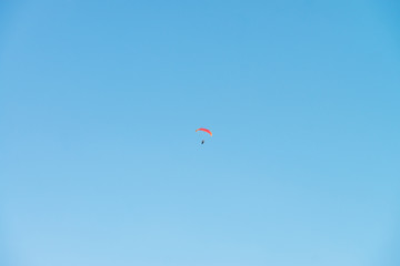 Paraglider in blue sky. Minimalistic style.
