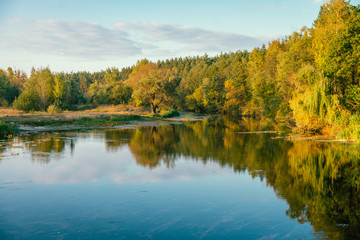 Fototapeta na wymiar Nature of Europe. River bank with trees in autumn sunset.