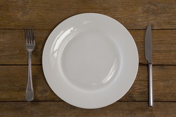 White plate with cutlery on table