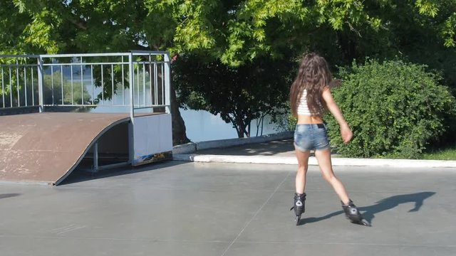 A teenager goes rollerblading. Beautiful girl roller-skating.