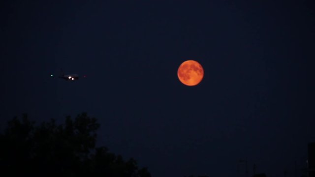 Wide, Airplane Flies By Orange Moon In Night Sky