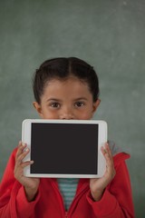 Young girl holding digital tablet against her face