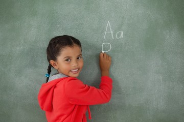 Young girl writing on chalk board