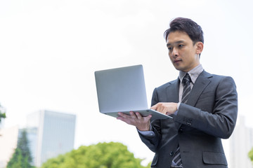 portrait of young asian businessman in park