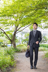portrait of young asian businessman in park