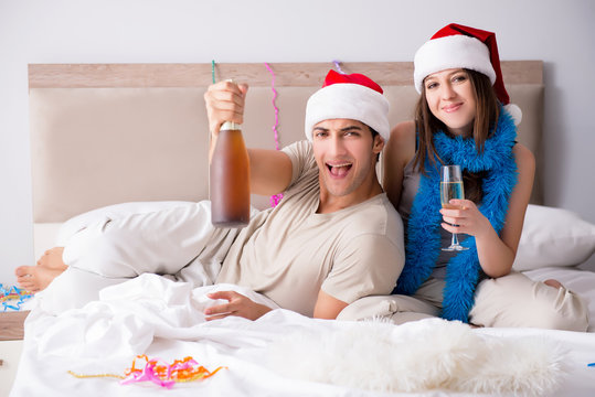 Happy couple celebrating christmas holiday in bed