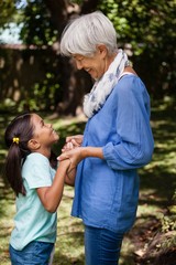 Side view of grandmother and daughter standing while holding