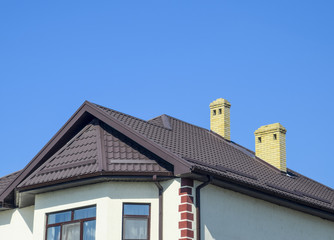 House with plastic windows and roof of corrugated sheet. Roofing of metal profile wavy shape on the house with plastic windows