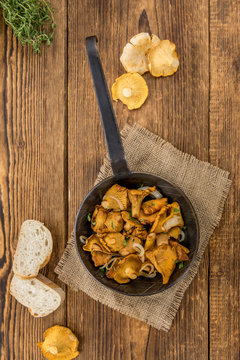 Fried Chanterelles on wooden background; selective focus
