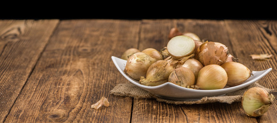 Portion of White Onions on wooden background, selective focus