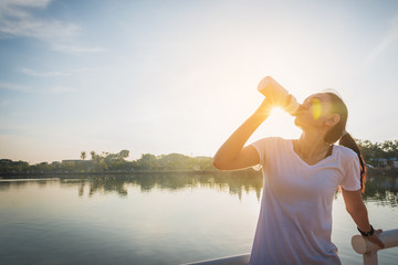 Healthy woman doing exercises and warm up before running and jogging on bridge at morning 