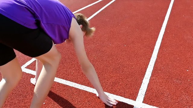 Track runner putting hands at starting line, slow motion