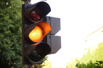 Yellow light of traffic lights in summer city