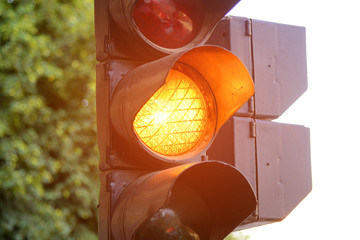 Yellow light of traffic lights in summer city