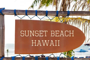 Foto auf Acrylglas Orange vintage signboard in shape of surfboard with Sunset Beach Hawaii text for surf spot and palm tree in background © stanciuc