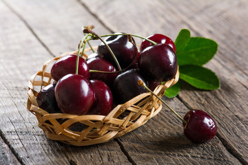 Cherry on a wooden table in a wicker