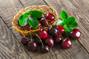 Cherry on a wooden table in a wicker