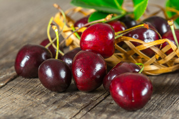 Cherry on a wooden table in a wicker