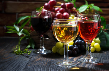 glasses of wine on dark wooden background