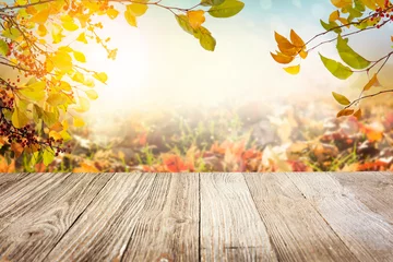 Poster Wooden table with autumn leaves background © Mariusz Blach
