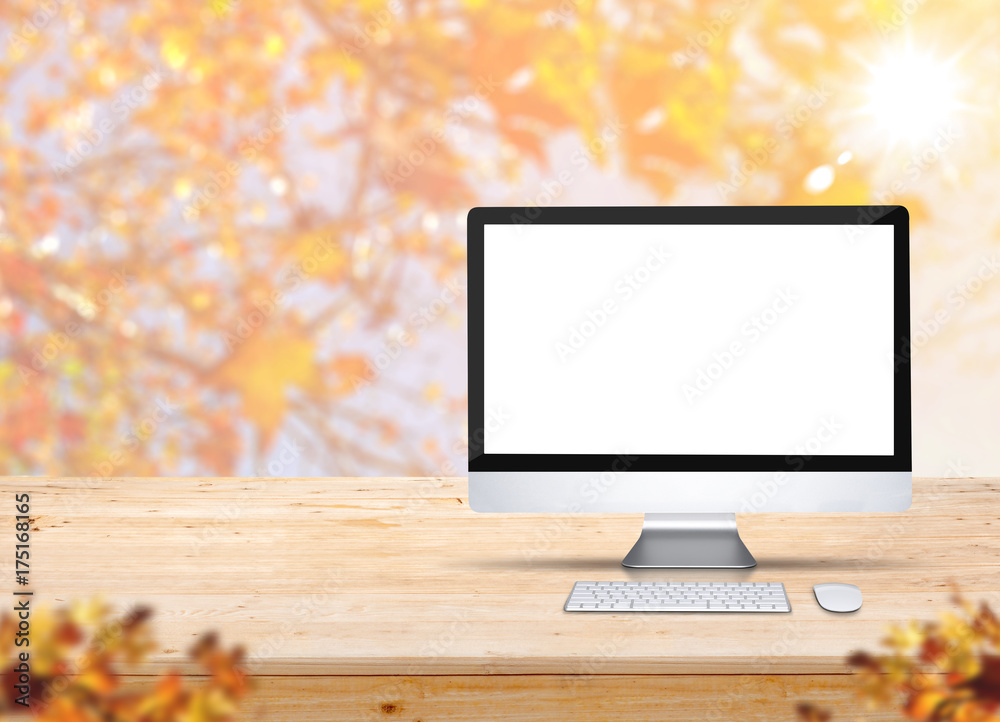 Aufkleber Computer desktop with keyboard and mouse on wood table with blur maple leaf with sunlight and blurred leaves at foreground,Autumn Mock up for display of product,banner for advertise on online
