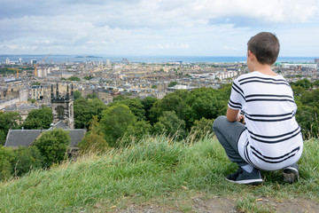Fototapeta na wymiar Young man looking at Edinburgh from Calton Hill