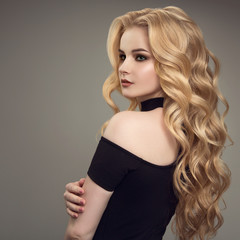 Fototapeta premium Blond woman with long curly beautiful hair.
