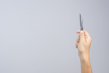 Hand holding sharp pocket fold metal knife
