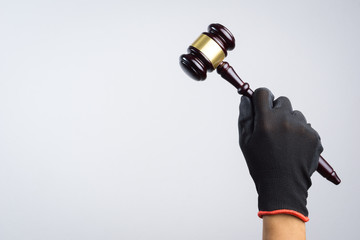 Hand holding wooden judge's gavel as a illegal or injustice sign
