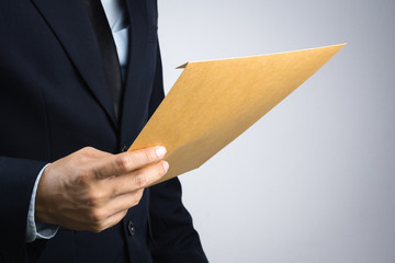 Business man hand holding a self sealing brown envelope document