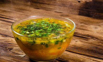 Vegetable soup in a glass bowl on wooden table