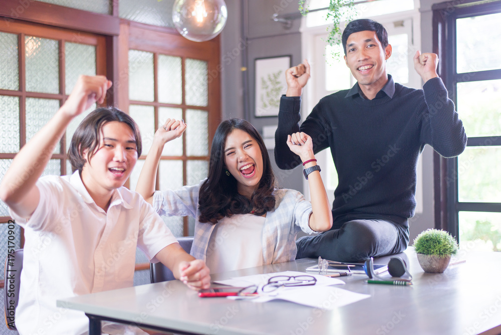 Wall mural group of successful freelancers is celebrating working together sitting in coworking space