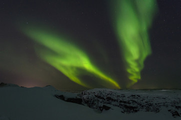 Tundra and hills covered with snow and polar lights.
