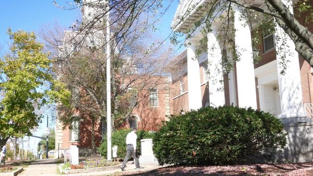Man walks up to a town hall in small american town during daytime