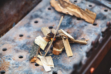 Small wood chips are stacked around fire in grill