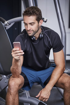 Gym dude texting on Smartphone