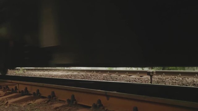 Rusty wheels of heavy passenger train are slowly passing by.