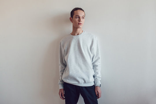 Young man in gray sweatshirt on white background. Mock-up.