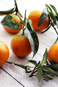 Tangerines with leaves on wooden background. Mandarins Rustic st