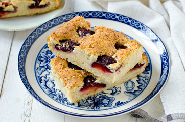 Plum cake with caramel on a white wooden table
