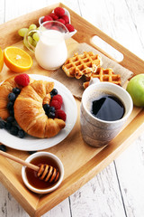 Breakfast served with coffee, orange juice, croissants and fruit