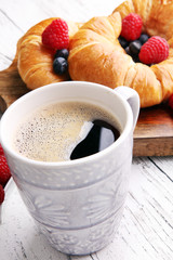 Delicious breakfast with fresh croissants and ripe berries on ta