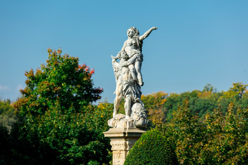 Fototapeta na wymiar Classic statue in a park with blue sky and tree on background