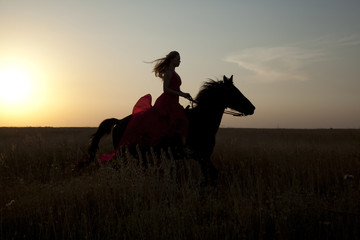 Girl riding a horse on sunset background