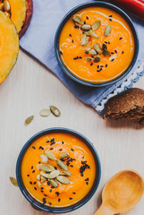 Homemade vegetable soup with pumpkin with cream and black sesame, top view with copy space