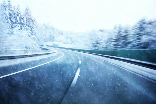 Abstract dangerous fast highway winter driving. Snowy conditions on the road. Motion blur visualizies the speed and dynamics.