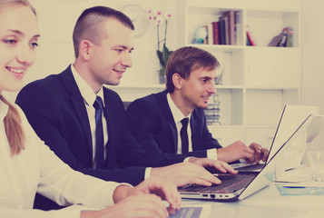 Young business male sitting with coworkers