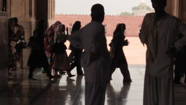People In Black Light Walking Near Mosque Entrance - Static 
